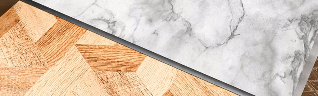 AC38 Cover Plate in Pewter between a light marble tile and a oak floor covering. 