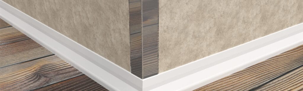 Vertex Corner Wall Protection in Stainless Steel, on a light brown wall with a white skirting board and a dark wood floor. 